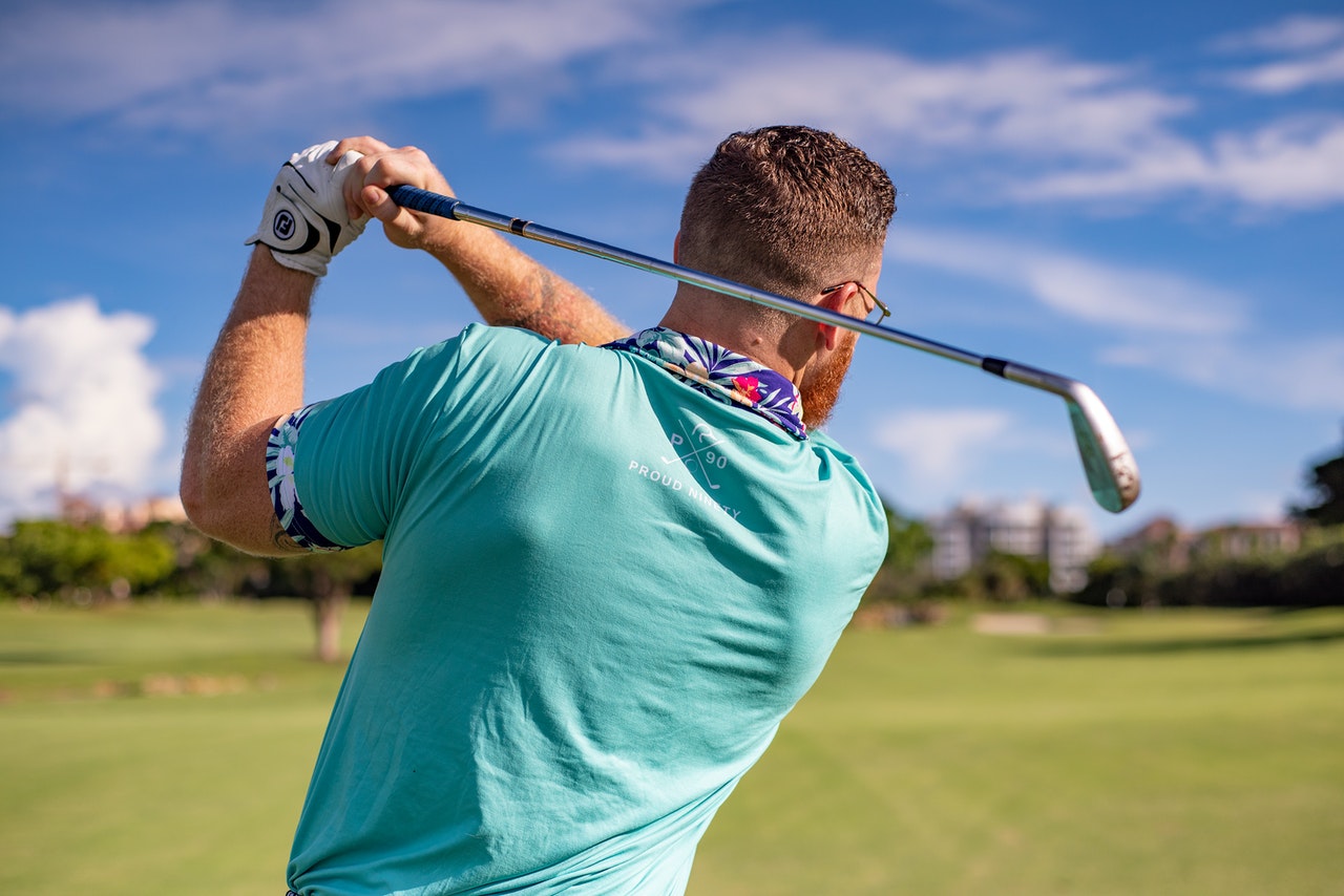 A lean man playing golf