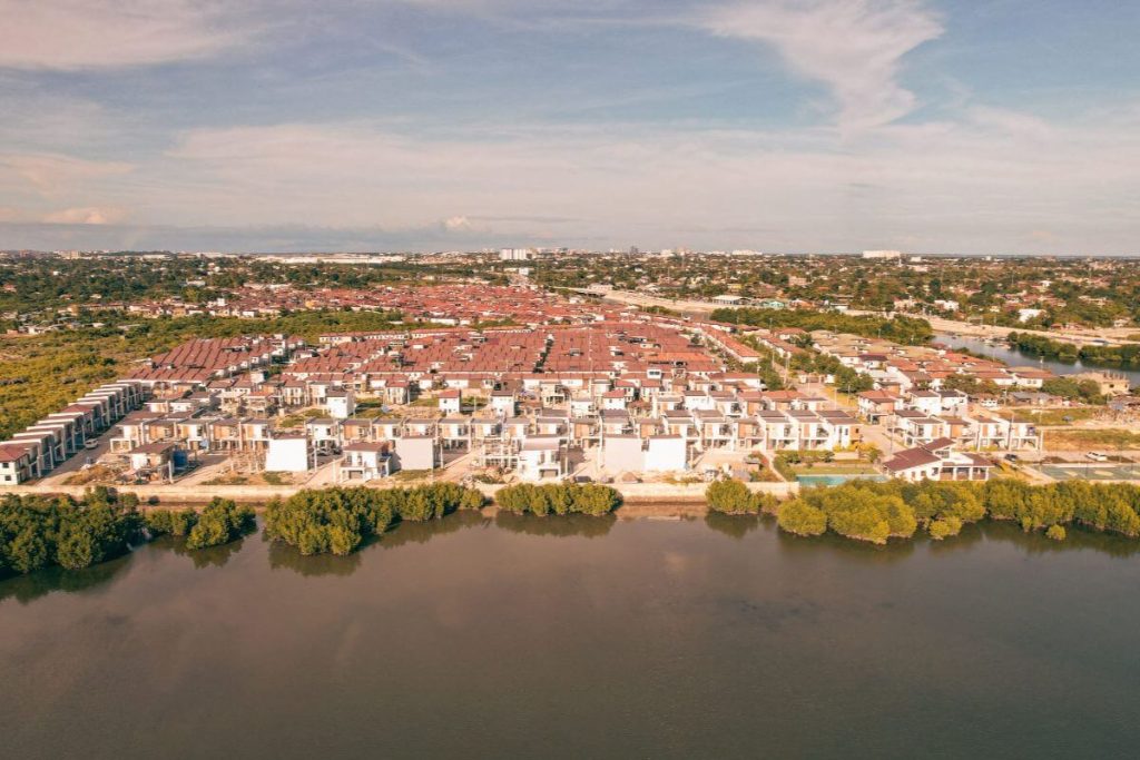 Aerial view of a waterfront residential community in Cebu featuring modern homes and a strategic location near urban centers.